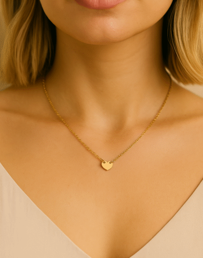 Femme portant un collier petit cœur doré en acier inoxydable.