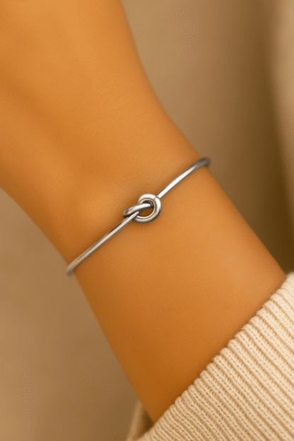 Bracelet jonc fin avec nœud central en acier inoxydable argenté porté au poignet