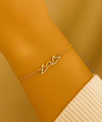 Bracelet vague en acier inoxydable doré porté au poignet par une femme