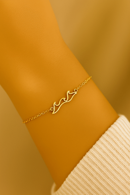 Bracelet vague en acier inoxydable doré porté au poignet par une femme