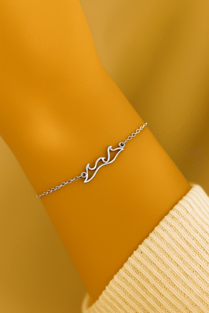 Bracelet vague en acier inoxydable argenté porté au poignet par une femme