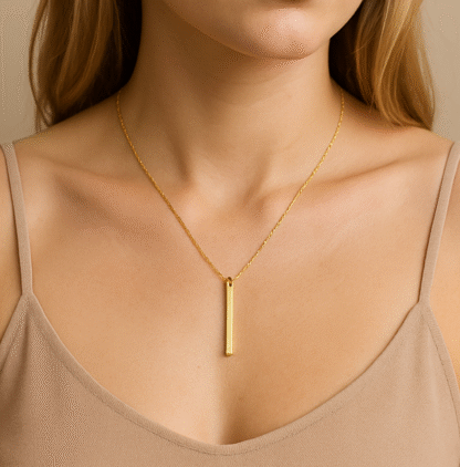 Femme portant un collier doré à barre verticale en acier inoxydable
