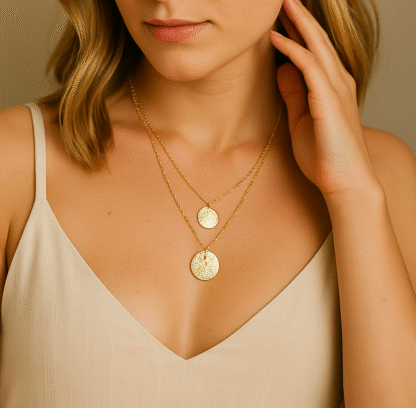 Zoom sur un collier double rang doré avec deux médailles martelées porté par une femme