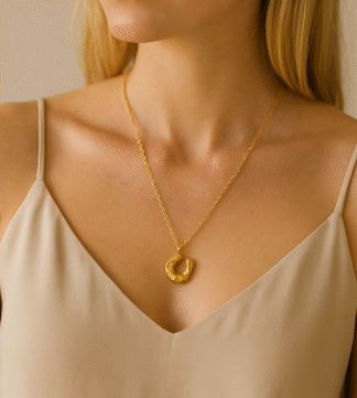 Femme portant un collier doré avec pendentif fer à cheval en acier inoxydable