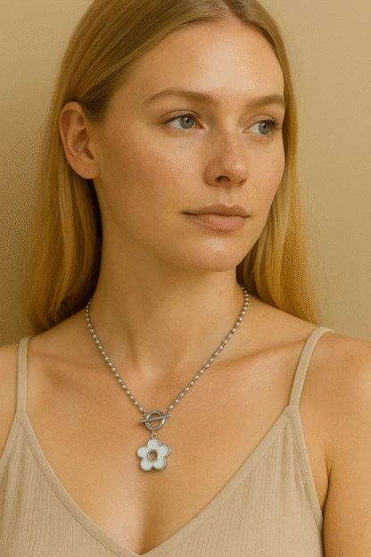 Femme blonde portant un collier ras du cou en acier inoxydable argenté avec pendentif fleur