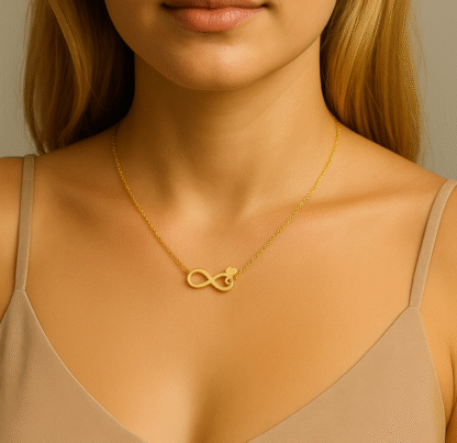 Femme portant un collier infini doré en acier inoxydable avec un petit cœur