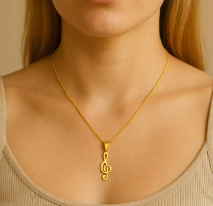 Gros plan d’un collier doré avec pendentif clé de sol porté par une femme