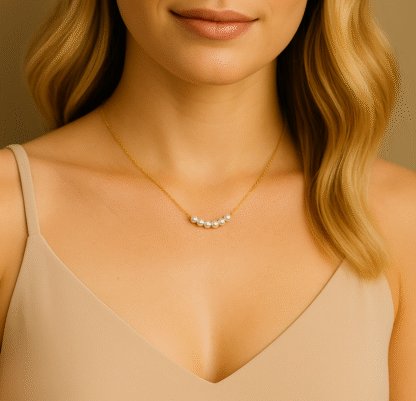 Femme portant un collier ras du cou doré avec perles blanches fantaisie, bijou élégant pour look quotidien ou soirée