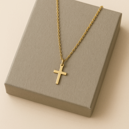 Collier ras du cou doré avec pendentif croix posé sur boîte grise