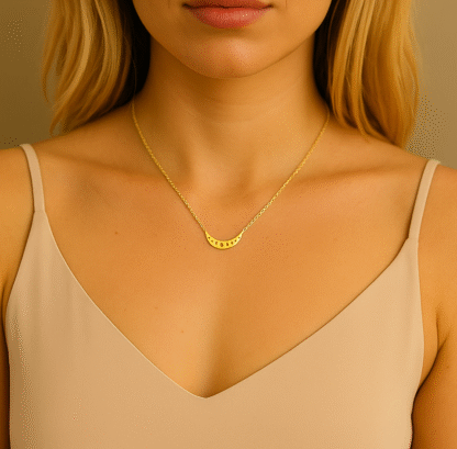 Collier doré avec pendentif croissant de lune porté par une femme