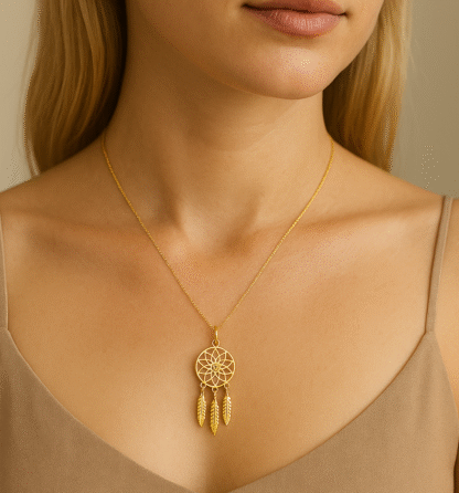 Femme portant un collier attrape-rêves doré en acier inoxydable avec top beige